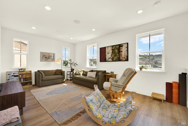 living area with a wealth of natural light, hardwood / wood-style floors, and recessed lighting