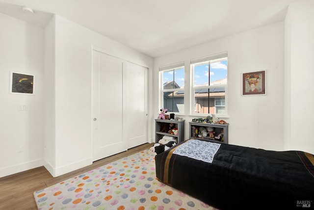 bedroom featuring a closet, baseboards, and wood finished floors