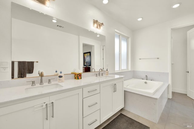 bathroom with tile patterned floors, a garden tub, visible vents, and a sink