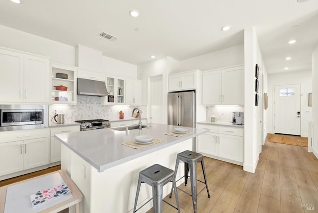 kitchen with visible vents, under cabinet range hood, light countertops, appliances with stainless steel finishes, and a sink