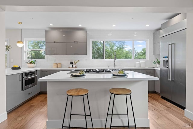 550 Sequoia Dr, San Anselmo, CA 94960 - kitchen featuring gray cabinets, a center island, modern cabinets, a breakfast bar area, and appliances with stainless steel finishes