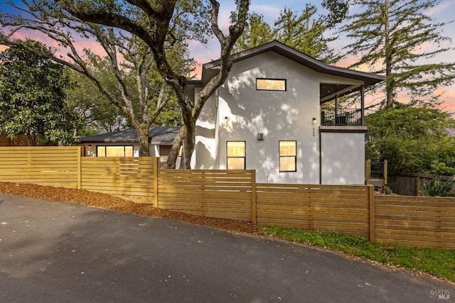 550 Sequoia Dr, San Anselmo, CA 94960 - property exterior at dusk with a balcony, stucco siding, and a fenced front yard