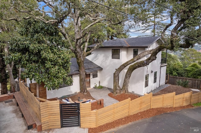 550 Sequoia Dr, San Anselmo, CA 94960 - view of front facade featuring roof with shingles, a fenced front yard, stucco siding, and a gate
