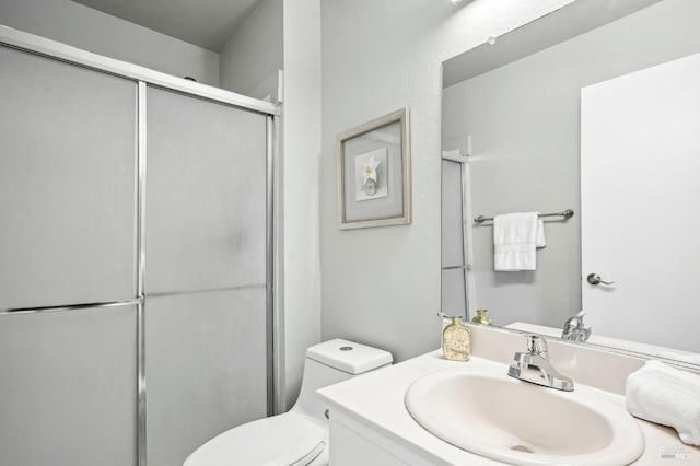 bathroom featuring a stall shower, vanity, and toilet