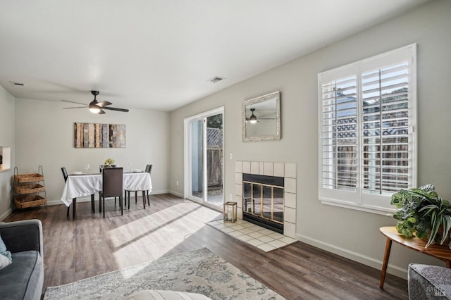 living room with a healthy amount of sunlight, a fireplace, visible vents, and wood finished floors