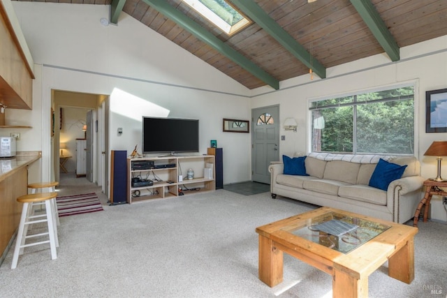 carpeted living area with wooden ceiling, high vaulted ceiling, a skylight, and beam ceiling