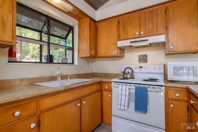 kitchen with brown cabinetry, white appliances, and under cabinet range hood