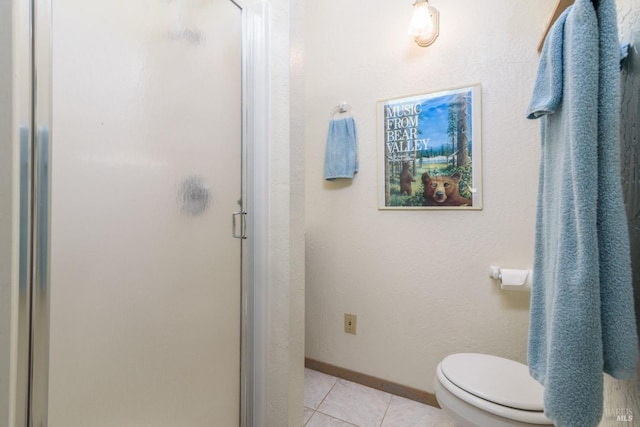 full bathroom featuring toilet, a shower stall, baseboards, and tile patterned floors