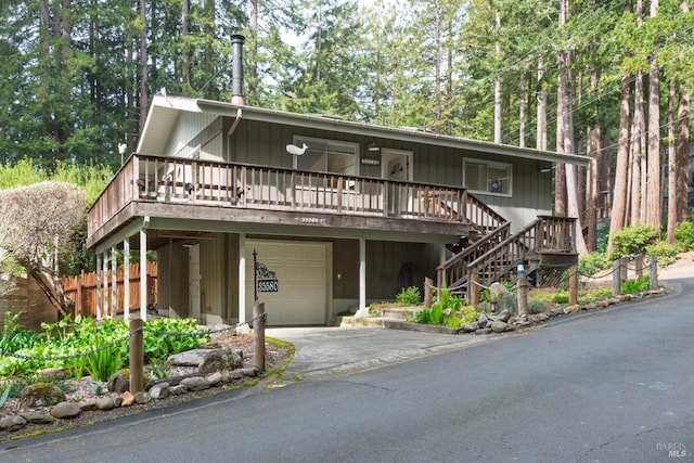 view of front facade with driveway, covered porch, a garage, and stairway