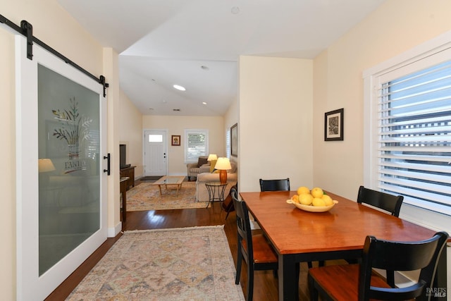 dining room with a barn door, baseboards, lofted ceiling, dark wood-style flooring, and recessed lighting