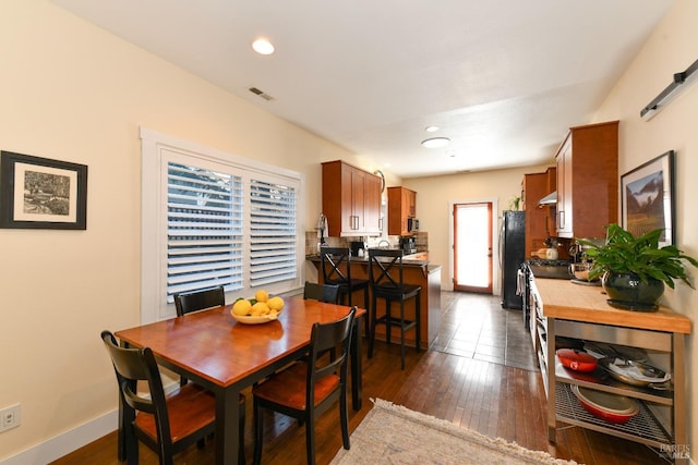 dining space featuring dark wood-type flooring, recessed lighting, visible vents, and baseboards