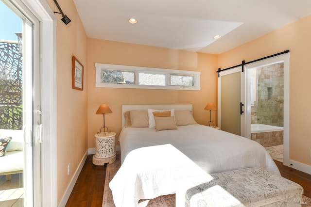 bedroom with a barn door, recessed lighting, wood finished floors, and baseboards