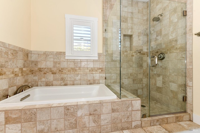 bathroom featuring a garden tub and a shower stall