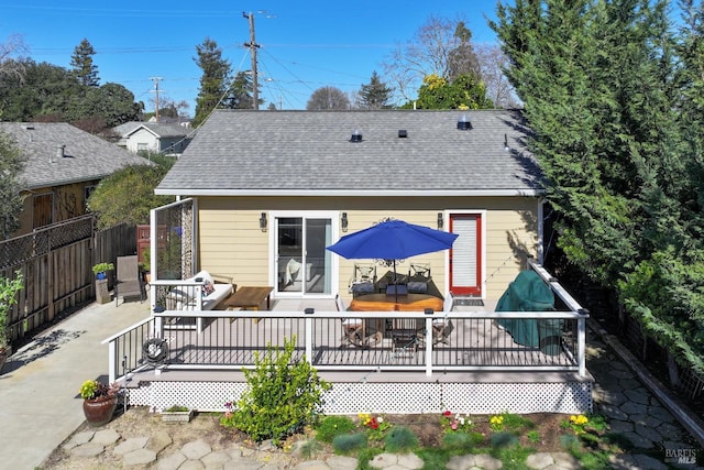 rear view of house featuring an outdoor hangout area, a shingled roof, fence, and a wooden deck