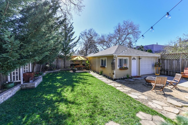 view of yard featuring a fenced backyard, an outdoor structure, a fire pit, and a patio