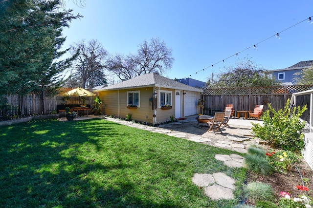 back of house with an outbuilding, a yard, a patio, a fenced backyard, and a fire pit