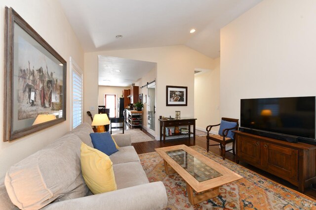 living area featuring recessed lighting, a barn door, vaulted ceiling, wood finished floors, and baseboards