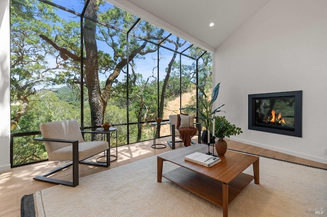 sunroom featuring lofted ceiling and a glass covered fireplace