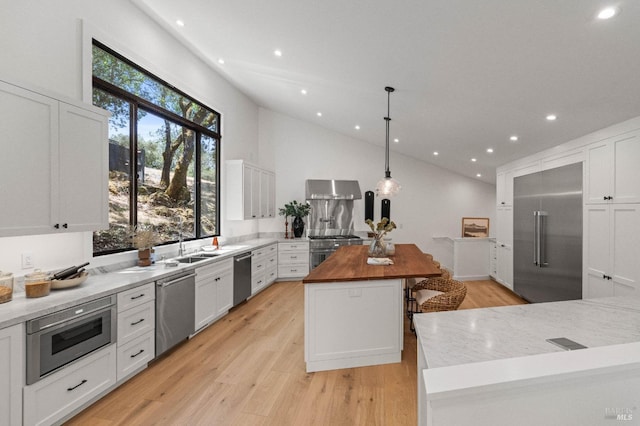 kitchen featuring a center island, white cabinets, light wood-style flooring, and built in appliances