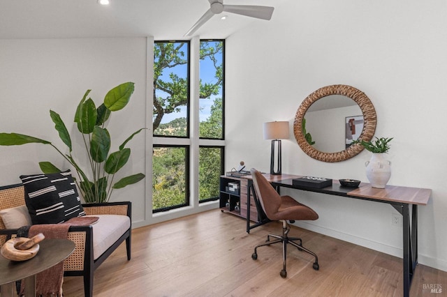 home office with recessed lighting, plenty of natural light, wood finished floors, and floor to ceiling windows