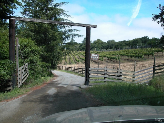 surrounding community featuring a rural view and fence