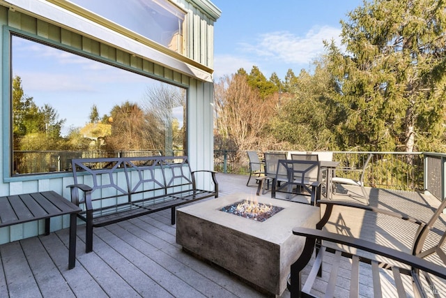 deck featuring outdoor dining space and an outdoor fire pit