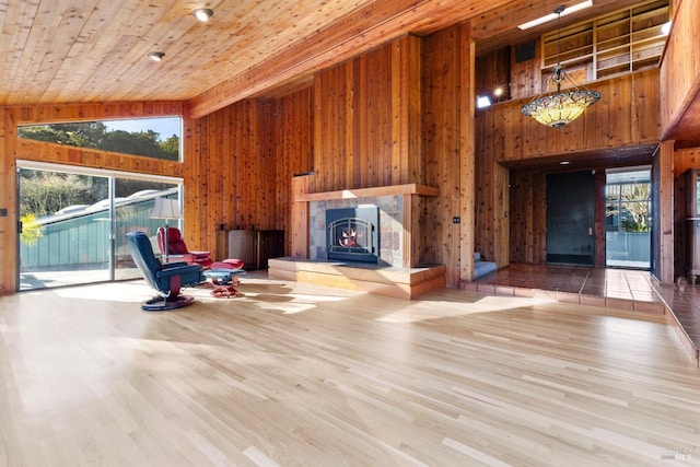 unfurnished room featuring wooden ceiling, wood walls, high vaulted ceiling, and wood finished floors