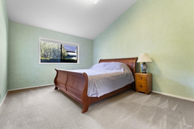 carpeted bedroom featuring vaulted ceiling and baseboards