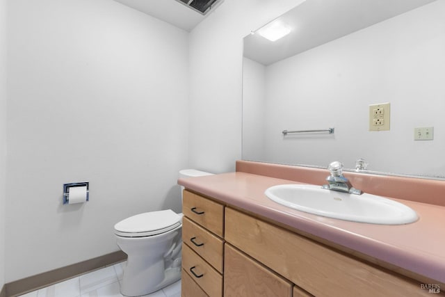 bathroom with visible vents, vanity, toilet, and baseboards