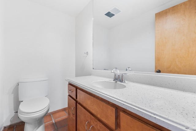 half bath with toilet, tile patterned flooring, and vanity