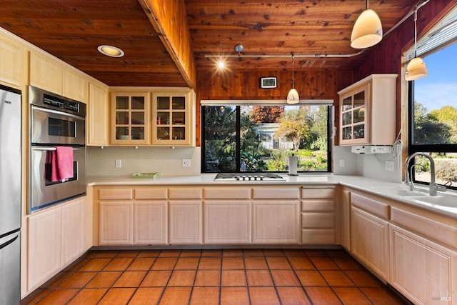 kitchen featuring stainless steel appliances, wood ceiling, light countertops, and a sink