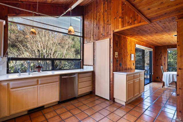 kitchen featuring stainless steel dishwasher, wood ceiling, light countertops, and a sink