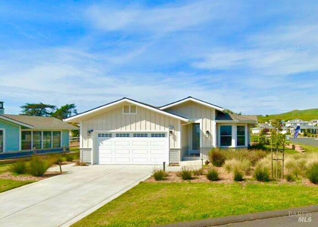 view of front of property with a garage, driveway, a front lawn, and board and batten siding