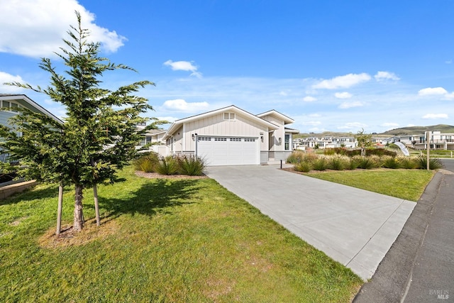 view of front facade with a front yard, concrete driveway, board and batten siding, and an attached garage