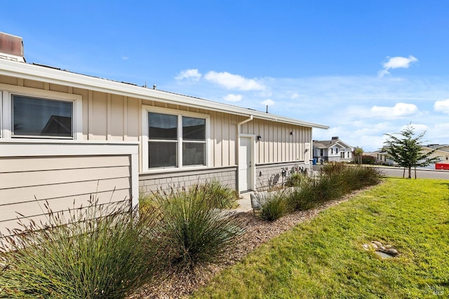 view of side of property with a yard and board and batten siding