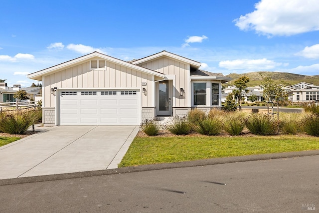 view of front of home featuring a mountain view, concrete driveway, a garage, and board and batten siding