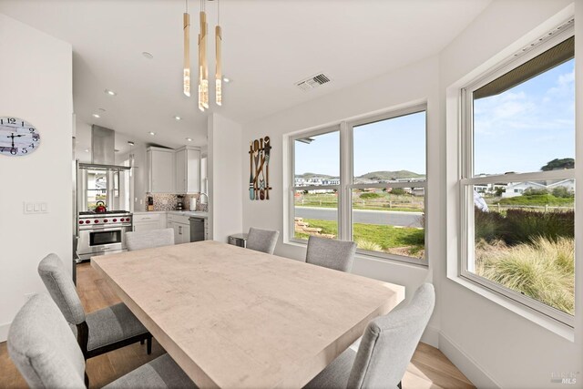 dining area featuring light wood-style flooring, recessed lighting, baseboards, and visible vents