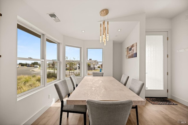 dining area with visible vents, baseboards, and light wood finished floors