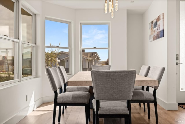 dining space featuring light wood-type flooring and baseboards