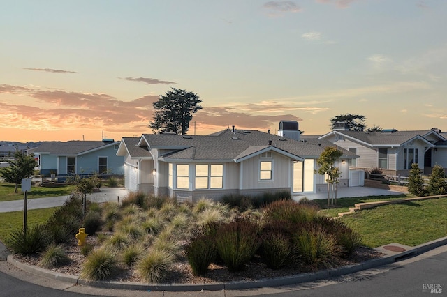 view of front of property featuring an attached garage, a residential view, driveway, and roof with shingles