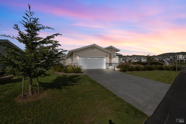 view of front of house featuring board and batten siding, a yard, a garage, and driveway