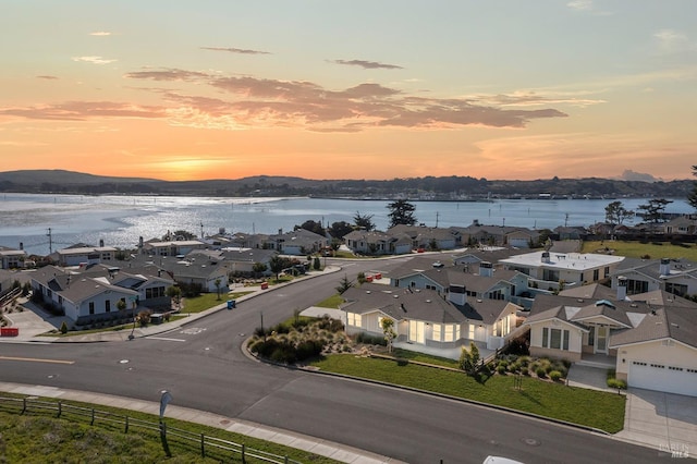 aerial view at dusk with a residential view and a water view