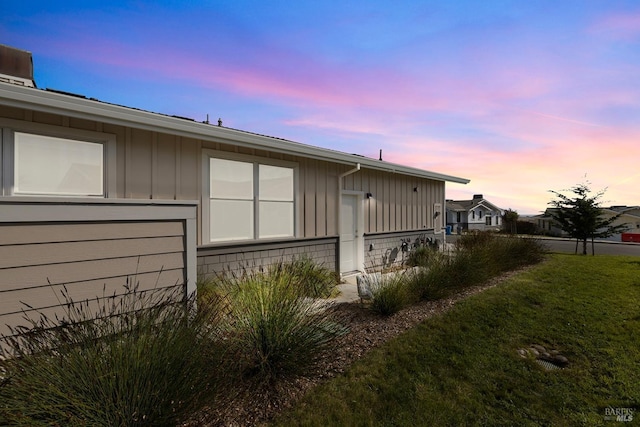 view of side of property featuring a lawn and board and batten siding