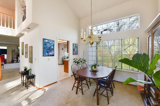 carpeted dining room with high vaulted ceiling, baseboards, and a chandelier