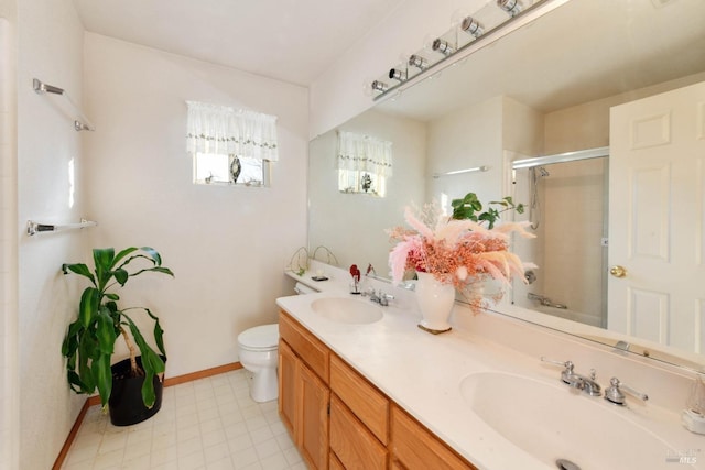 bathroom with toilet, a sink, a shower with shower door, and baseboards