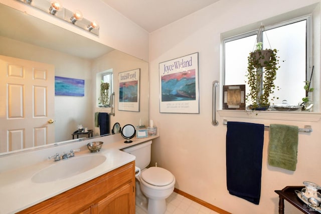 bathroom with vanity, toilet, and baseboards