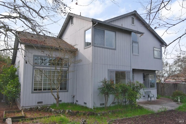 back of property with crawl space, a patio area, and fence