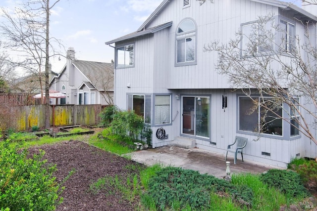 rear view of property featuring crawl space, a patio area, and fence