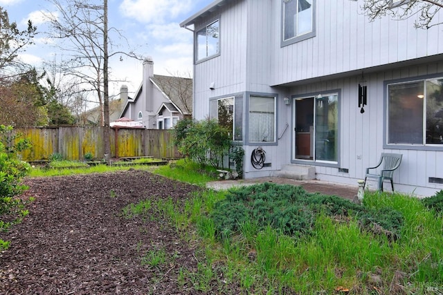 rear view of house featuring fence