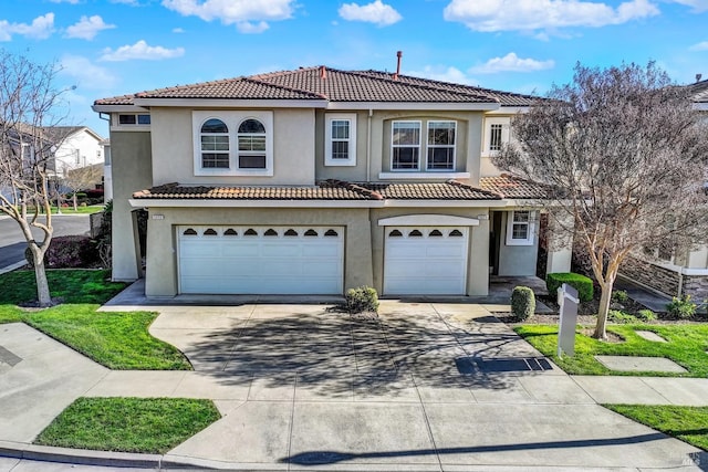 view of front facade with concrete driveway, a tiled roof, an attached garage, and stucco siding